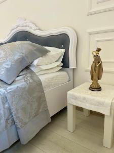 een witte slaapkamer met een bed en een tafel bij Vintage apartment in Lviv