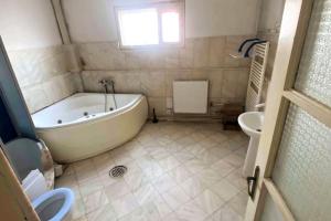 een badkamer met een wit bad en een wastafel bij Mirage The Welcome Rest Villa Self Service ! Cazare muncitori Ploiești ! Workers Accommodation ! in Ţînţăreni