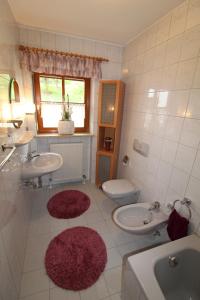 a bathroom with two sinks and a toilet and two mirrors at Ferienwohnung Leixenring in Riedenburg