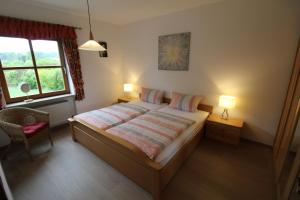 ein Schlafzimmer mit einem Bett mit zwei Lampen und einem Fenster in der Unterkunft Ferienwohnung Leixenring in Riedenburg