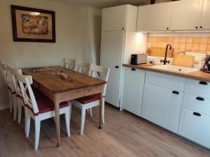 een keuken met een houten tafel en witte kasten bij Reiterhof - Welsh Cob Gestüt in Kasseedorf