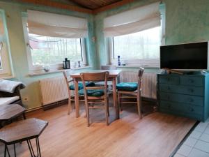 uma sala de jantar com uma mesa e cadeiras e uma televisão em Reiterhof - Welsh Cob Gestüt em Kasseedorf