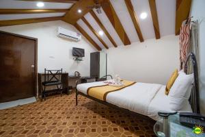 SUMMER GREEN RESORT في سيكَندراباد: غرفة نوم بسرير ومكتب في غرفة