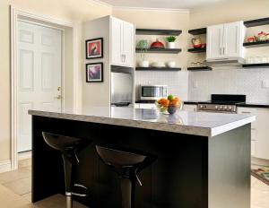 a kitchen with a counter with two bar stools at Little Paradise with Sauna Garden near Downtown in Saratoga +26 photos