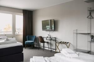 HovaにあるBriQ Hotellのベッド、テーブル、椅子が備わるホテルルームです。