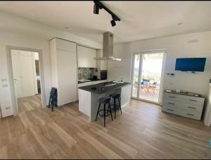 a large kitchen with a counter and chairs in it at Sciara Eolie in Lipari