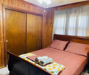 een slaapkamer met een bed met een houten hoofdeinde bij Terrace Guest House in Tampa