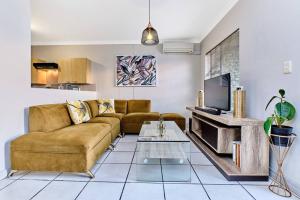 a living room with a couch and a tv at Westpoint Executive Suites, Sandton, Johannesburg in Johannesburg