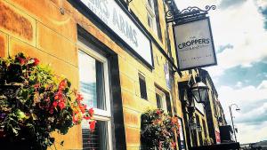 a sign on the side of a building with flowers at Croppers Arms in Huddersfield