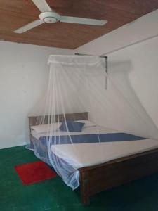 Schlafzimmer mit einem Bett und einem Deckenventilator in der Unterkunft Chandi Relax Hostel in Sigiriya