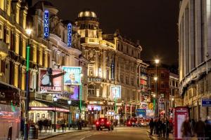 a busy city street at night with people and buildings at Impeccable 4-Bed House in Brixton London in London