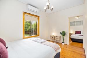 a bedroom with a large white bed and a window at Swainson on Margaret in Oaklands