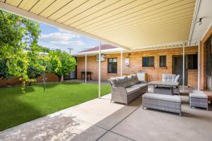 a patio with a couch and chairs and a lawn at Swainson on Margaret in Oaklands