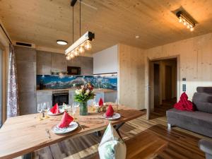 a kitchen and living room with a table and a couch at Alpenchalets Oberlaiming in Itter