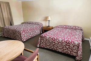 Habitación de hotel con 2 camas y mesa en Love Hotels Timberline at Lake Superior MI, en Ironwood