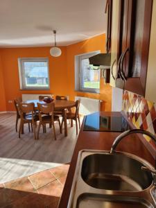 a kitchen and dining room with a table and chairs at Apartma Nika in Planina