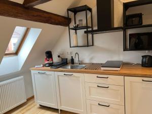 a kitchen with white cabinets and a sink at Hideaway im Odenwald nahe Heidelberg in Eberbach