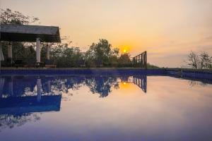 einen Pool mit Sonnenuntergang im Hintergrund in der Unterkunft Victoria Nui Sam Lodge in Chau Doc