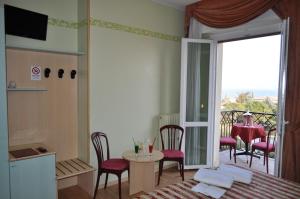 シルミオーネにあるHotel Alsaziaのベッド、テーブル、椅子が備わる客室です。