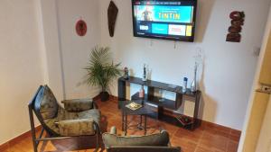 sala de estar con 2 sillas y TV de pantalla plana en Aires del Cerro en Yerba Buena
