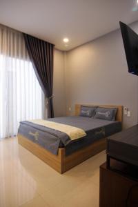 1 dormitorio con 1 cama y TV en Nemo Homestay, en Hue