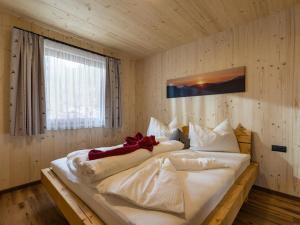 Schlafzimmer mit einem großen weißen Bett und einem Fenster in der Unterkunft Alpenchalets Oberlaiming in Itter