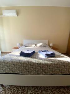 a bedroom with a bed with two towels on it at Casa Manolo Cesano Suite Apartment Milan in Cesano Boscone