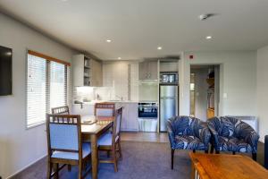 a kitchen and dining room with a table and chairs at Garden Court Suites & Apartments in Queenstown