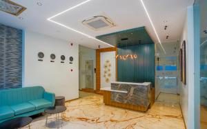 a store lobby with a blue couch and a fishtank at Apex Beacon Hotel, Mumbai in Mumbai