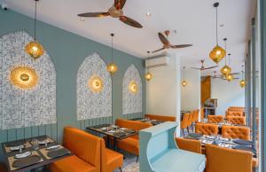 a dining room with orange chairs and tables at Apex Beacon Hotel, Mumbai in Mumbai