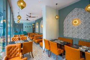 a dining room with orange chairs and tables at Apex Beacon Hotel, Mumbai in Mumbai