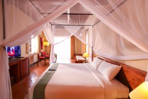 Victoria Nui Sam Lodge في تشاو دوك: غرفة نوم بسرير كبير مع مظلة