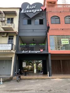 a moped parked in front of a building with a restaurant at Sky View Hotel Managed by OS in Batam Center