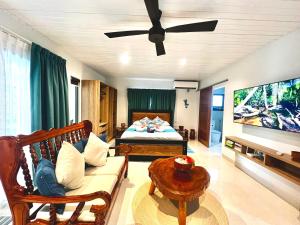 a living room with a couch and a bed at Le Port Guest House in Baie Sainte Anne