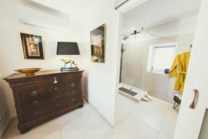 a bathroom with a shower and a dresser with a lamp at LES CENT CIELS in Salavas