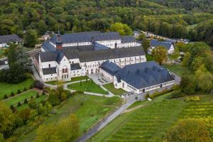 une vue aérienne sur un grand bâtiment blanc avec des toits noirs dans l'établissement Hideaway im Odenwald nahe Heidelberg, à Eberbach