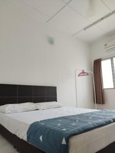 a bedroom with a large bed with a blue blanket at Wong Bentong Makmur Homestay in Bentong