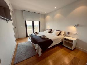a bedroom with a large bed and a large window at Soleada in Gijón