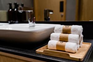 a stack of towels on a cutting board next to a sink at sleep 'n fly Sleep Lounge & Showers, B-Gates Terminal 3 - TRANSIT ONLY in Dubai