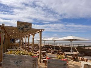 a restaurant on the beach with tables and umbrellas at The Nest in Prestatyn
