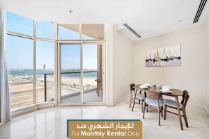 a dining room with a table and a view of the ocean at Mabaat - Obhour - 358 in Jeddah