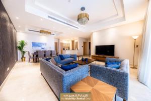 a living room with blue couches and a flat screen tv at Mabaat - Obhour - 358 in Jeddah