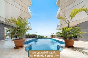 - une piscine au milieu d'un immeuble avec des plantes dans l'établissement Mabaat - Obhour - 358, à Djeddah