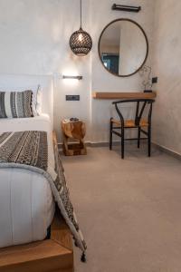 a bedroom with a bed and a mirror at Almyra Oia Suites in Oia