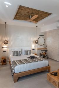 a bedroom with a large bed and two lights at Almyra Oia Suites in Oia