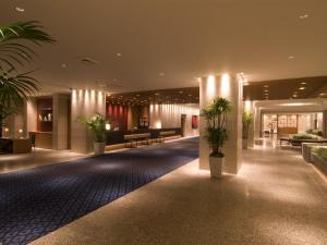 a lobby with potted plants in a building at Hotel Associa Shizuoka in Shizuoka