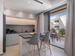 a kitchen with white cabinets and a table with chairs at Casa D'Irene Apts in Chania Town