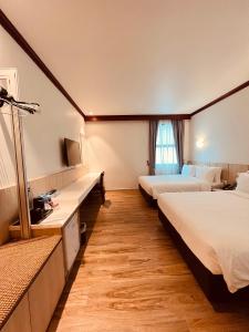 a hotel room with two beds and a television at Park View Hotel in Singapore