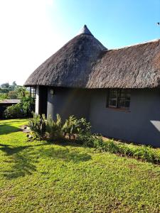 格拉斯科普Horizon View Chalets的茅草屋顶房屋,带庭院