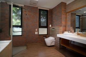 a bathroom with two sinks and a toilet at 畫日風尚會館Sinasera Resort in Changbin